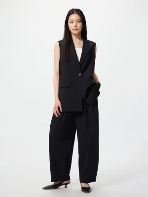 A model wearing wide black nylon pants paired with a sleeveless blazer, shown full-length against a plain background.