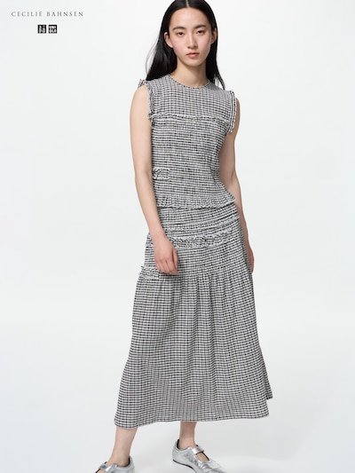 Model wearing a sleeveless black-and-white checkered one-piece dress shown full-length.