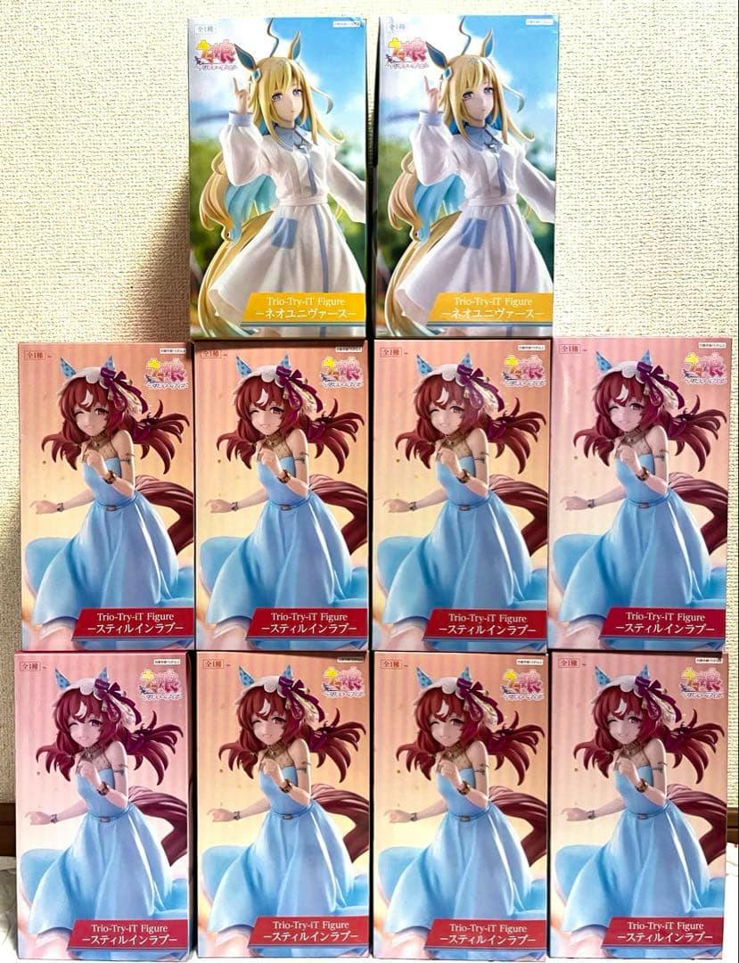 Photo of multiple boxed Trio-Try-iT figure boxes for ネオユニヴァース and スティルインラブ arranged in a grid.