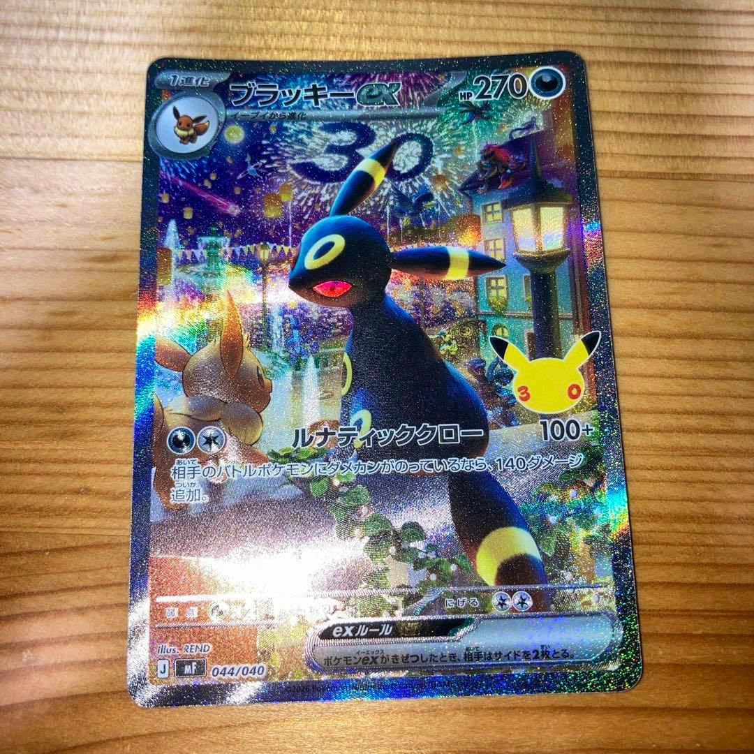 Photo of the ブラッキーex SAR Pokémon trading card (044/040) showing the full holographic card on a wooden surface.