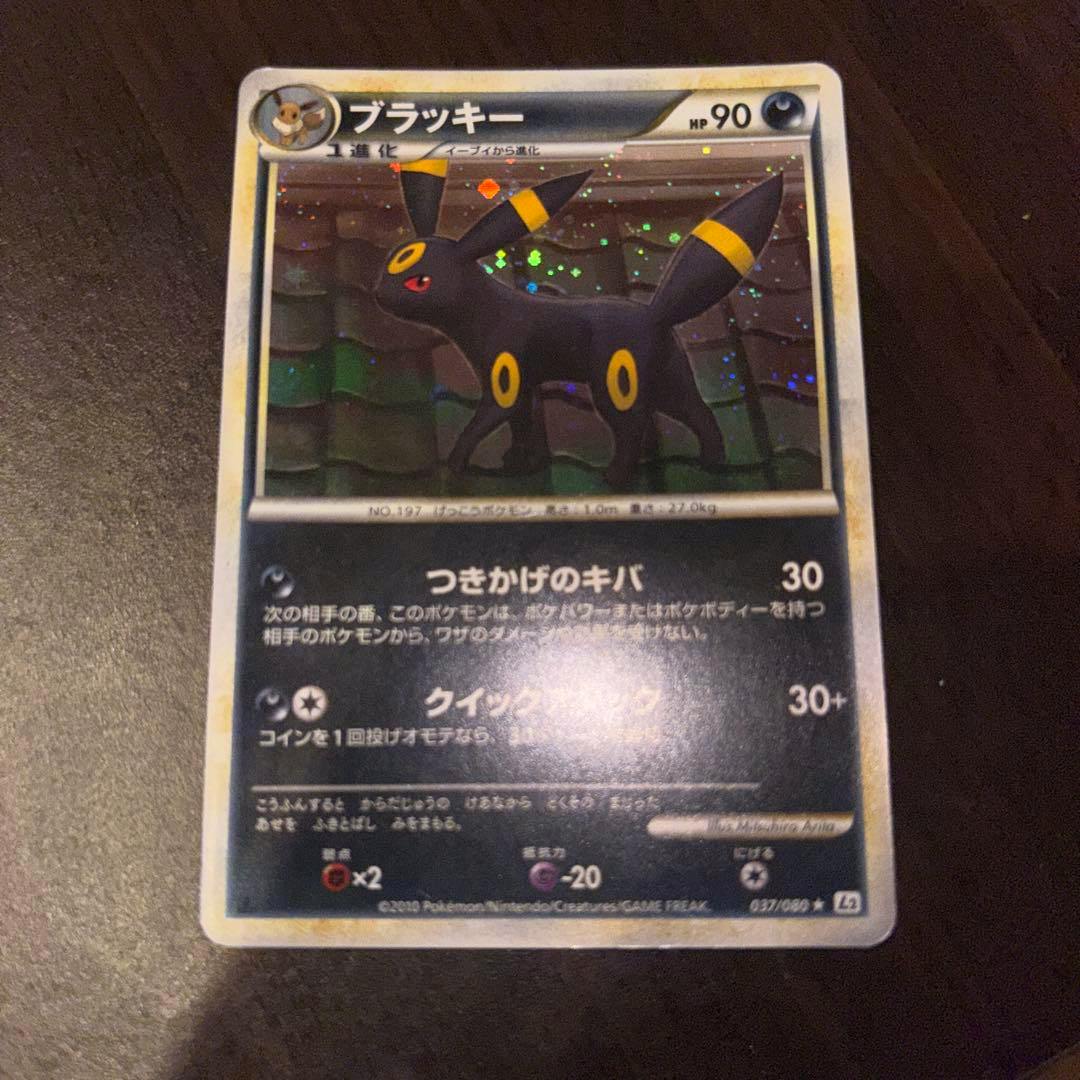 Front of the trading card showing Umbreon (ブラッキー) holographic artwork with Japanese text.