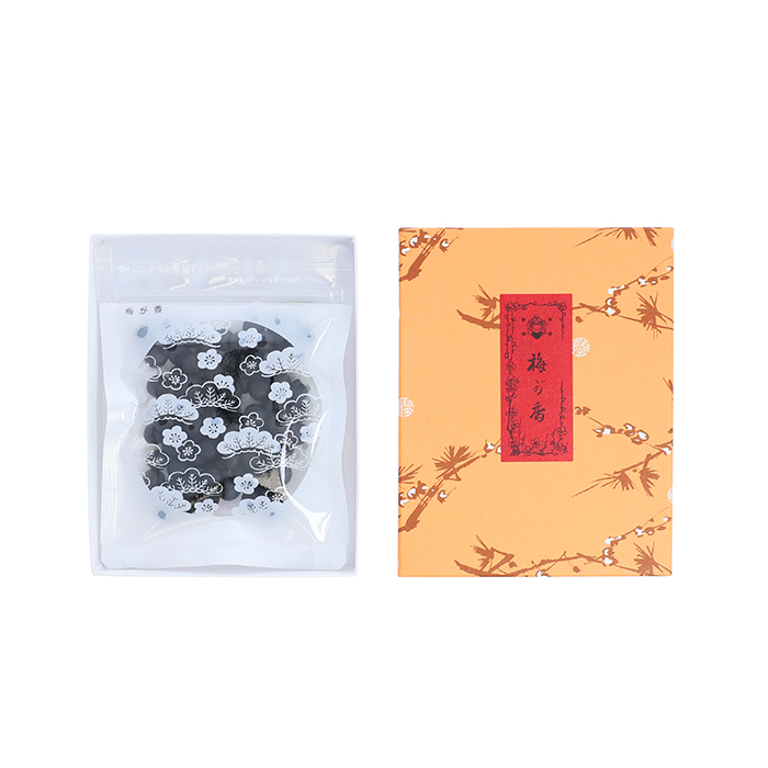 Resealable clear bag containing black incense pellets shown next to a decorative orange box.
