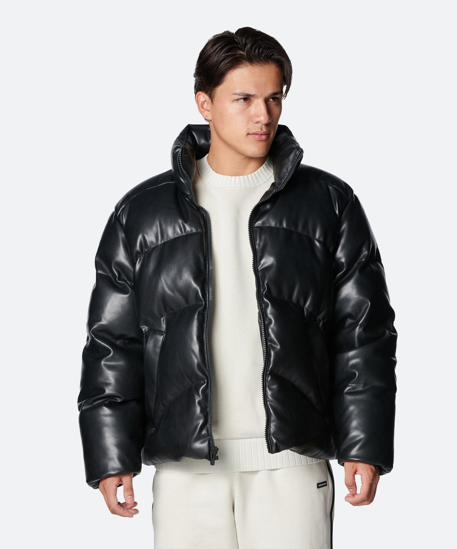 Male model wearing a black men's synthetic-leather puffer jacket shown front-on against a plain background.