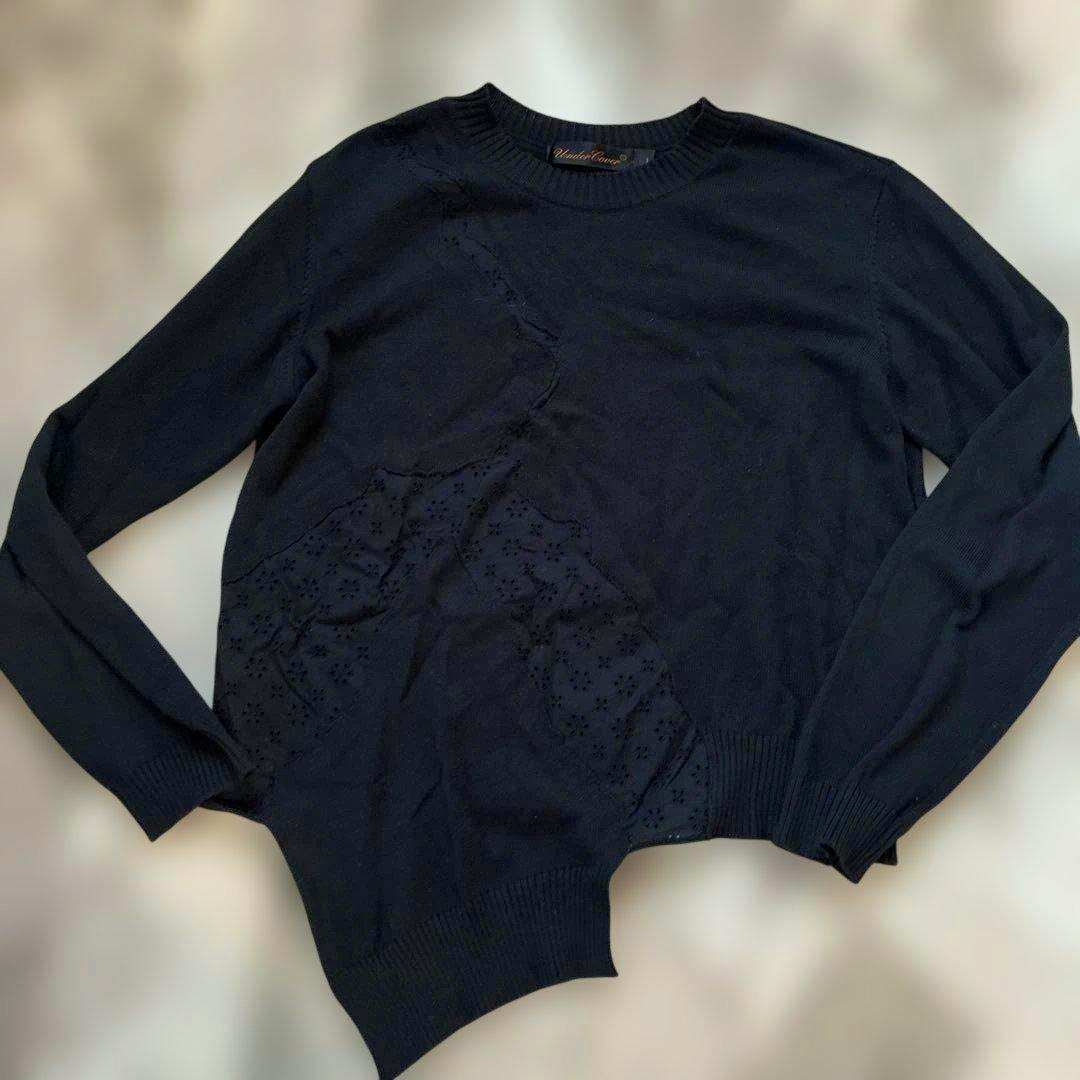 Flat-lay photo of a dark knit men's sweatshirt with long sleeves and cracked lace detail.