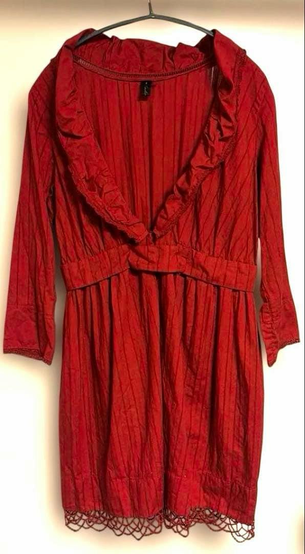 Red striped UNDERCOVER women's knee-length cotton dress with a ruffled V-neck and long sleeves hanging on a hanger.