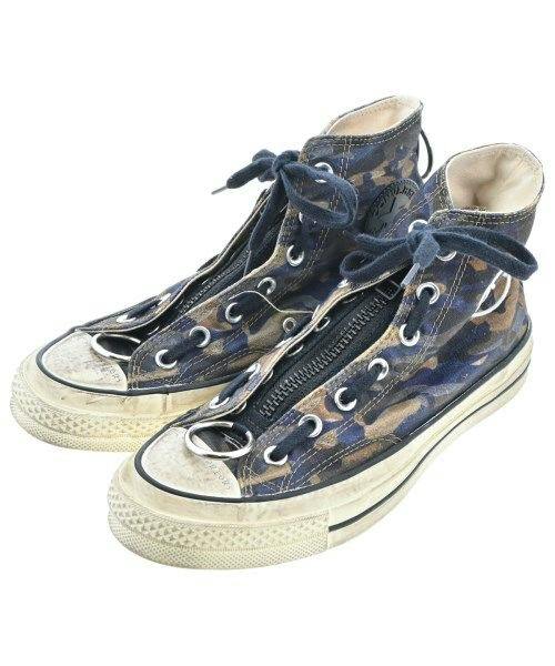 Pair of UNDER COVER women's camouflage high-top sneakers with center zippers and metal eyelets, shown from a front-side angle.