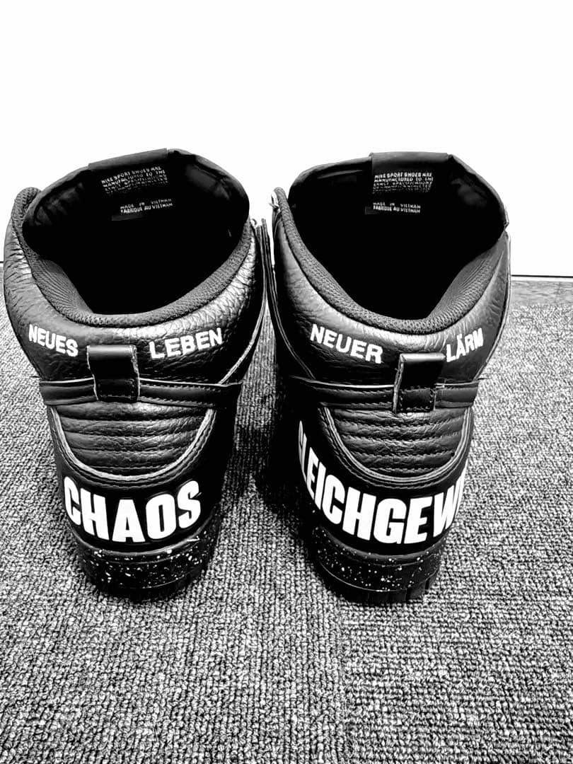 Rear view of a pair of black Nike Dunk High "Chaos" sneakers showing "CHAOS" printed on the heels and white text on the collars.