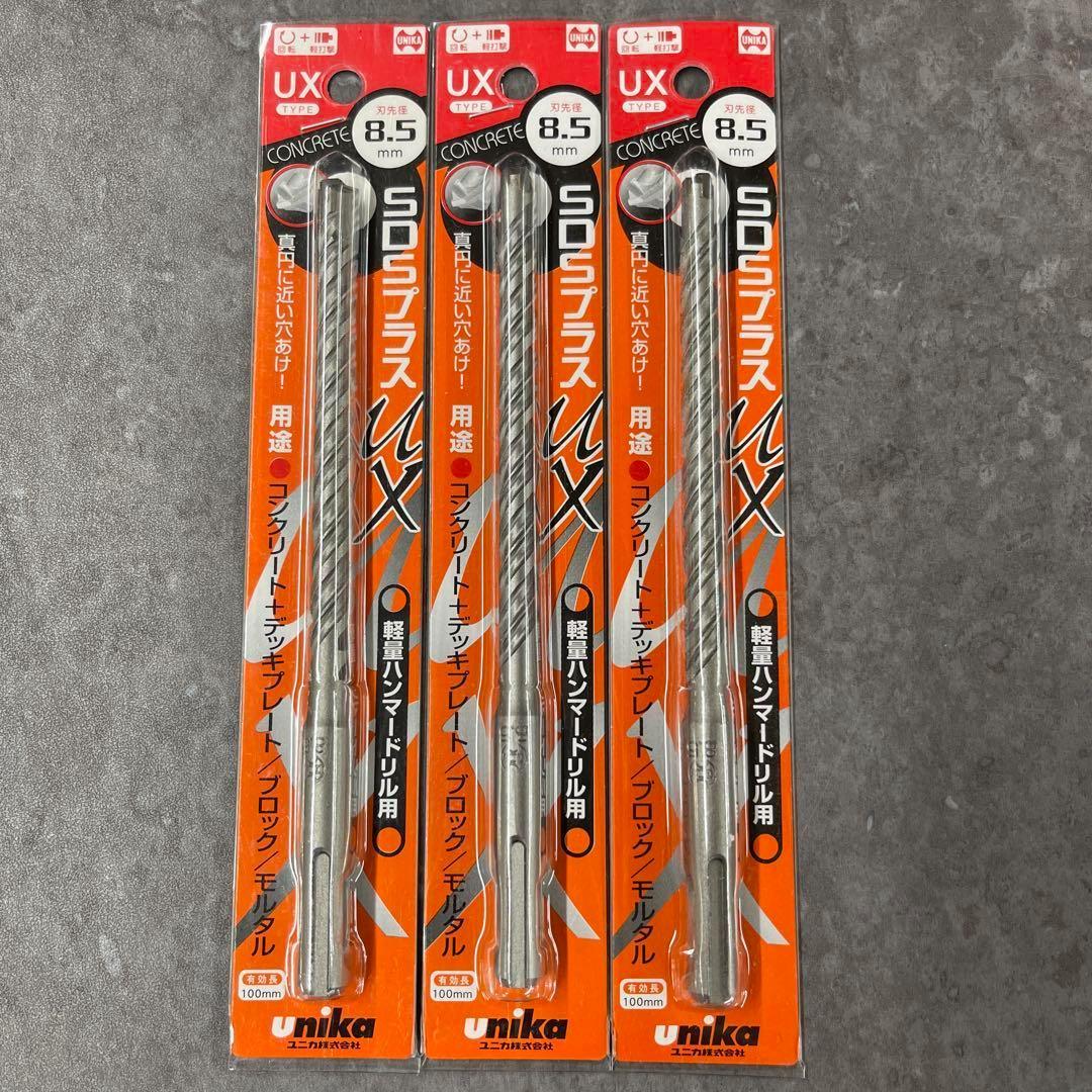 Three packaged Unika UX SDS-plus 8.5mm drill bits in orange blister cards shown side by side on a gray surface.