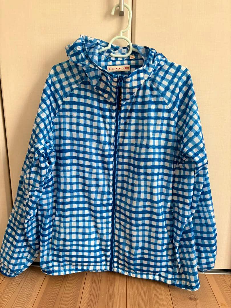Front view of the blue-and-white checkered UNIQLO and MARNI packable parka hanging on a hanger.