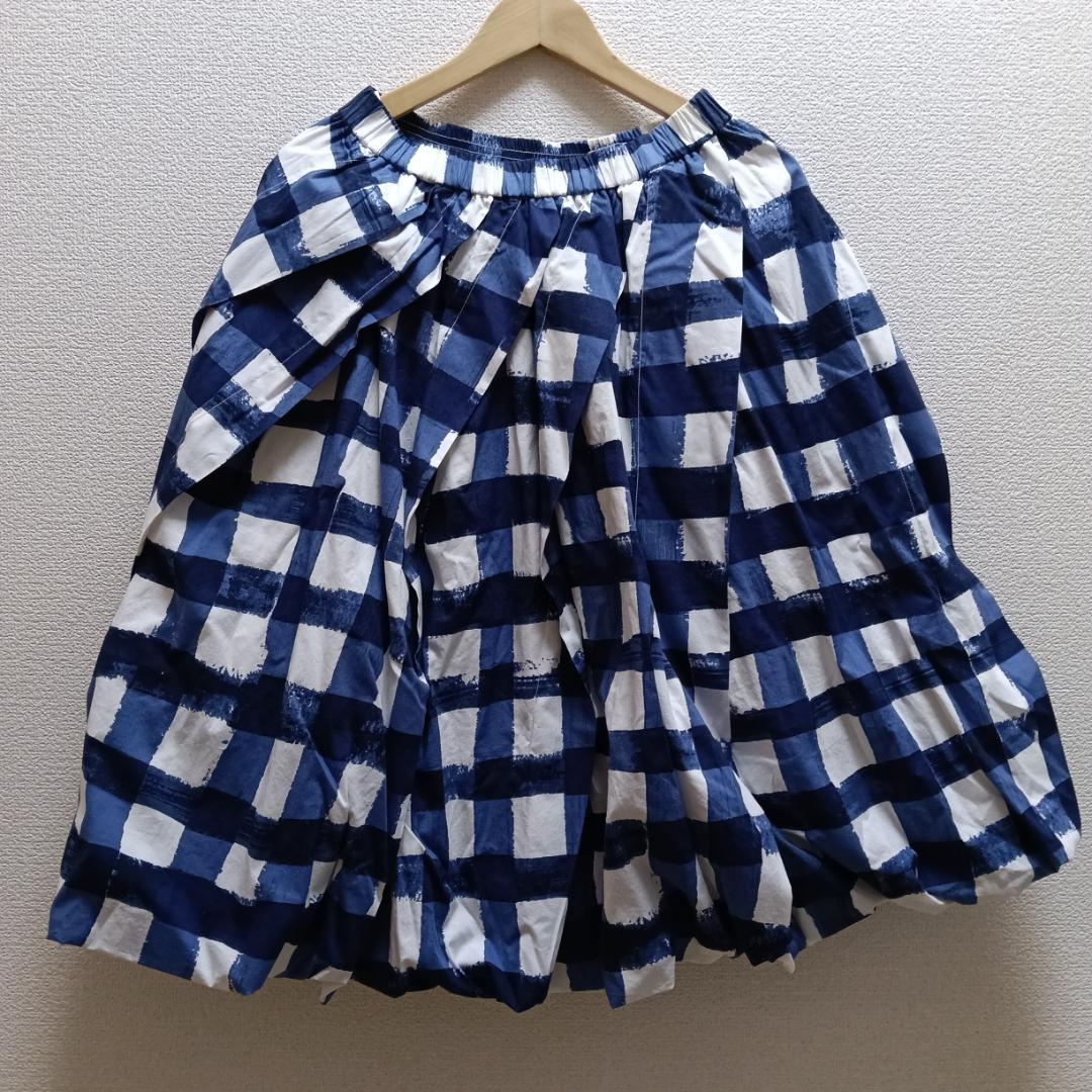 Blue and white checkered UNIQLO × MARNI balloon-shape women's skirt (size M) hanging on a wooden hanger against a wall.