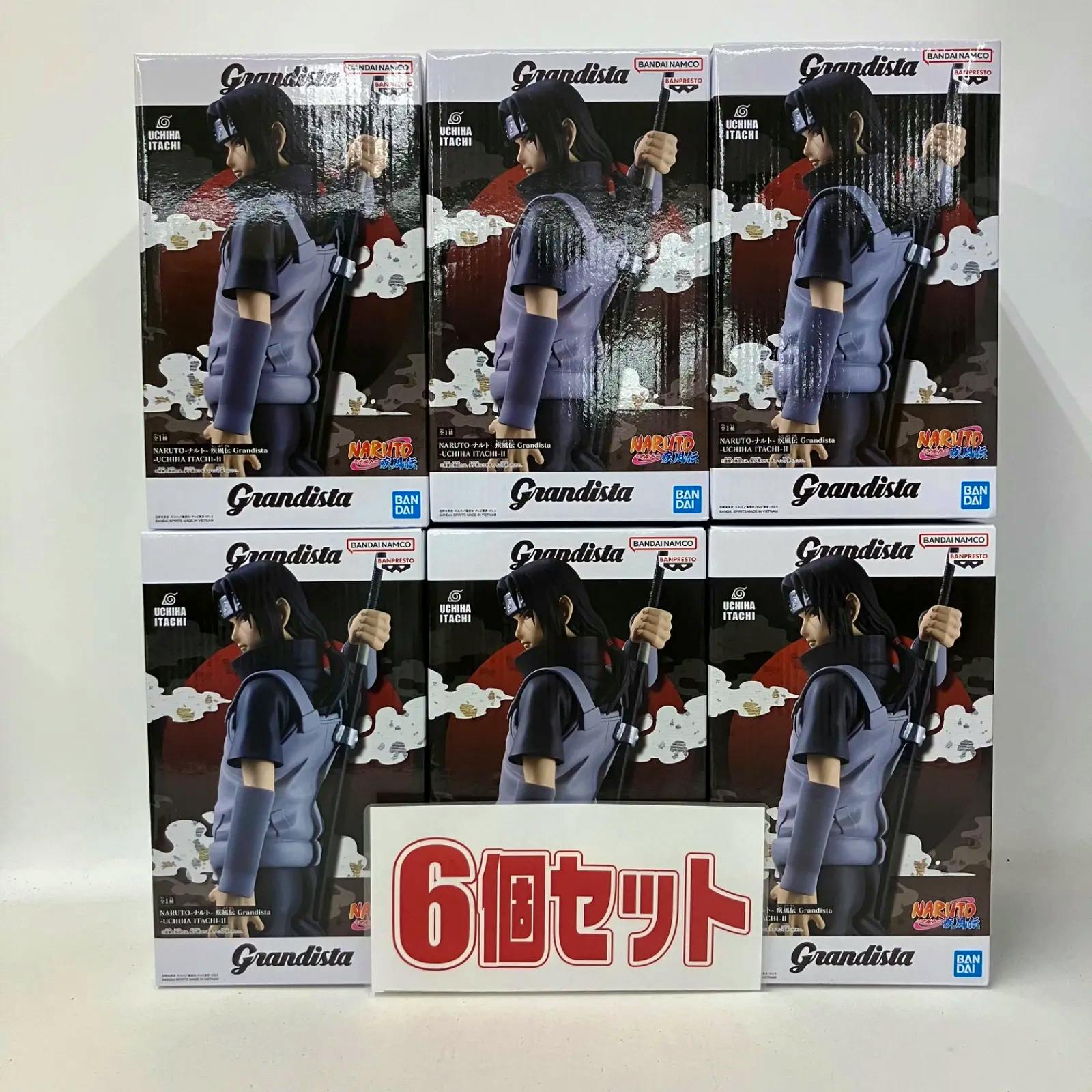 Six boxed Grandista Uchiha Itachi II Naruto figures stacked in two rows with a large sign reading “6個セット” in front.
