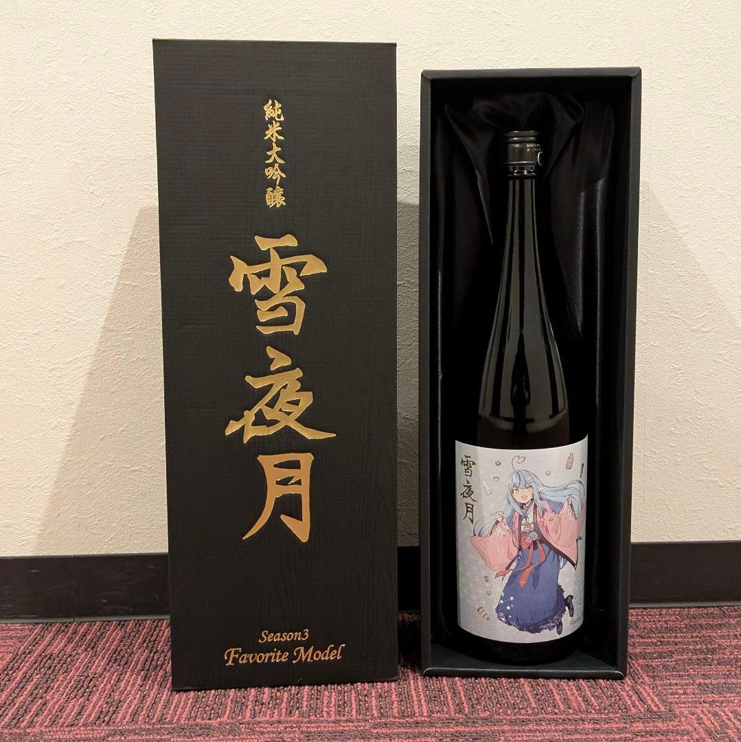 Sealed 1.8L bottle of sake labeled 「雪夜月」 with an illustrated character, displayed inside a black presentation box with its lid beside it.