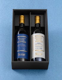Two bottles of the unsweetened bottled iced coffee set displayed in a black gift box on a light blue background.