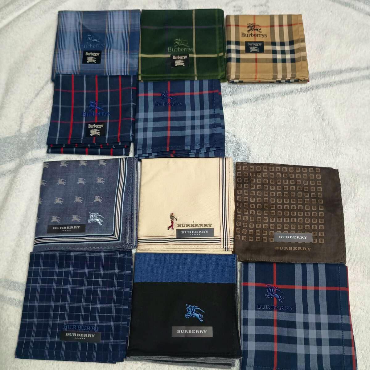 Eleven folded Burberry/Burberrys cotton handkerchiefs in assorted plaid and patterned designs displayed on a towel, with visible brand labels.