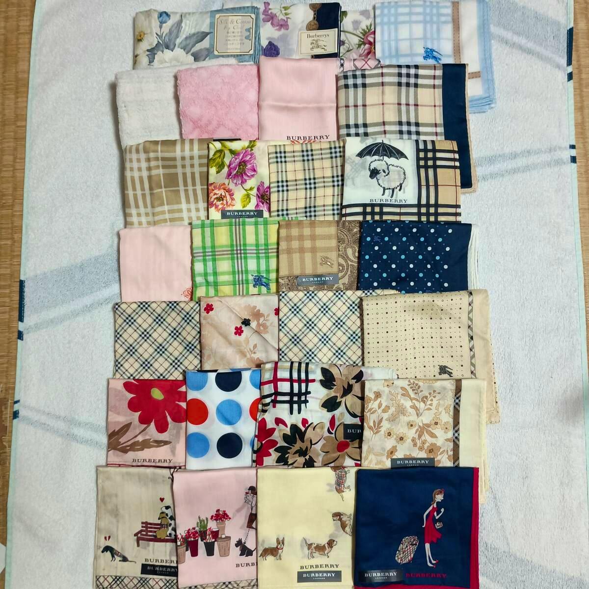 Top-down photo of the 28-piece set of Burberry and Burberrys cotton handkerchiefs arranged on a towel, showing assorted patterns and visible labels.