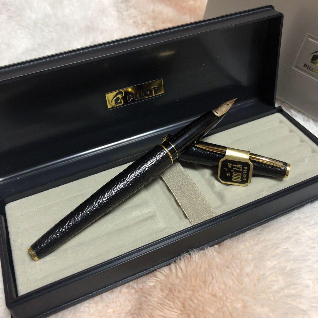 Leather-wrapped black Pilot fountain pen with the cap removed showing the nib, displayed in an open presentation box.