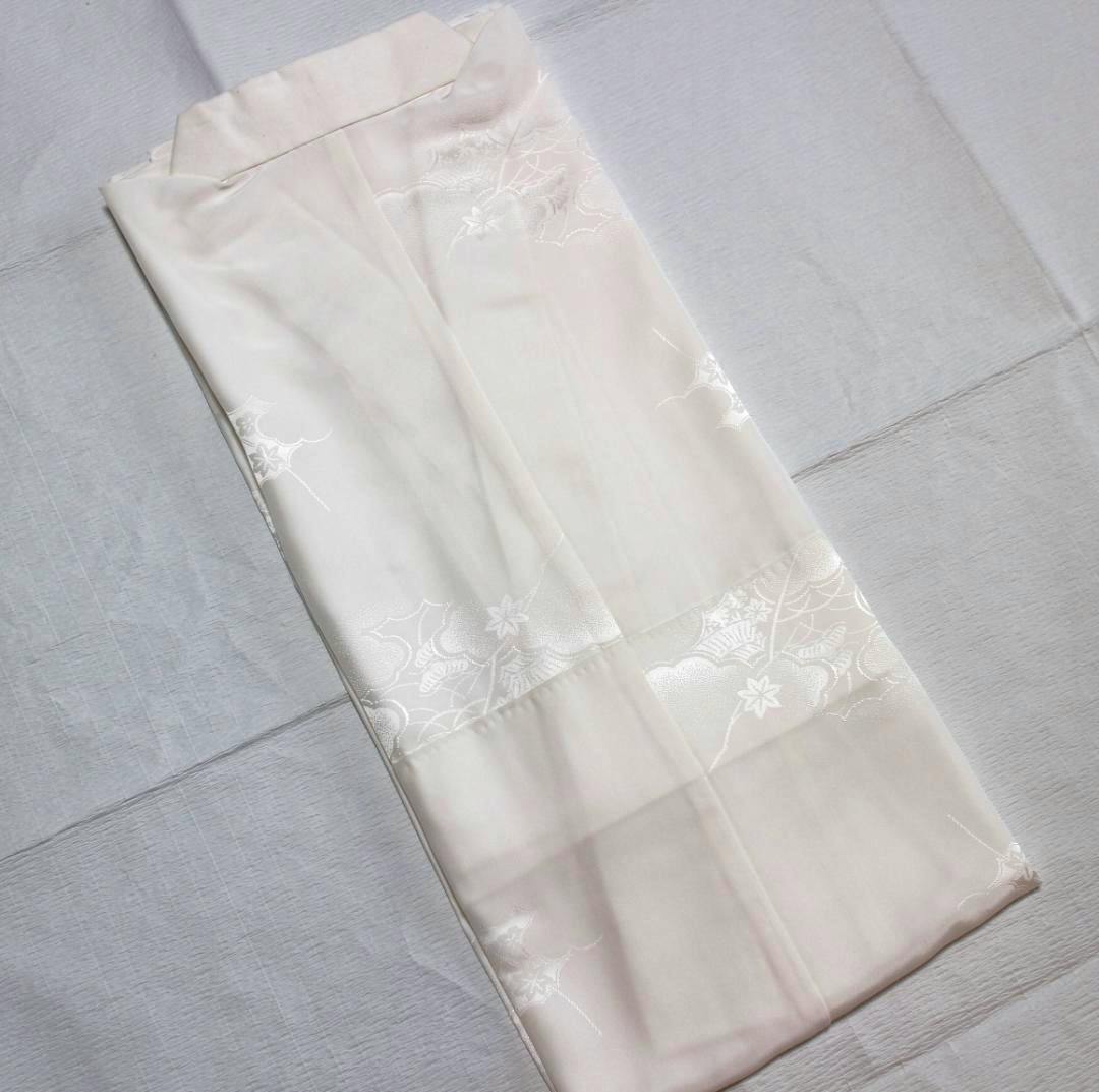 Folded single-layer nagajuban (長襦袢) showing a cloud-and-flower pattern on pale fabric.