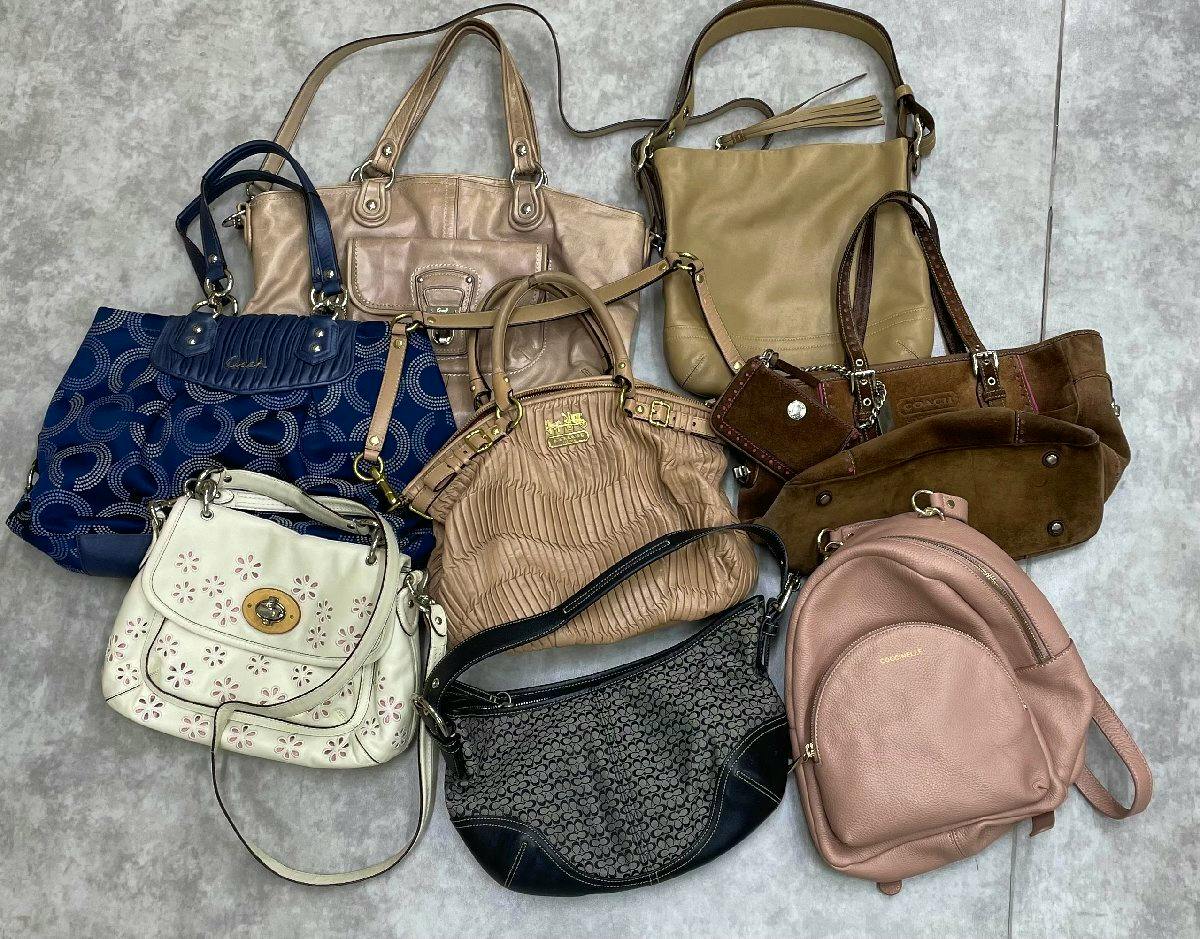 Eleven used bags of various styles and colors (totes, shoulder bags, handbags, small backpack) arranged together on a light floor background.