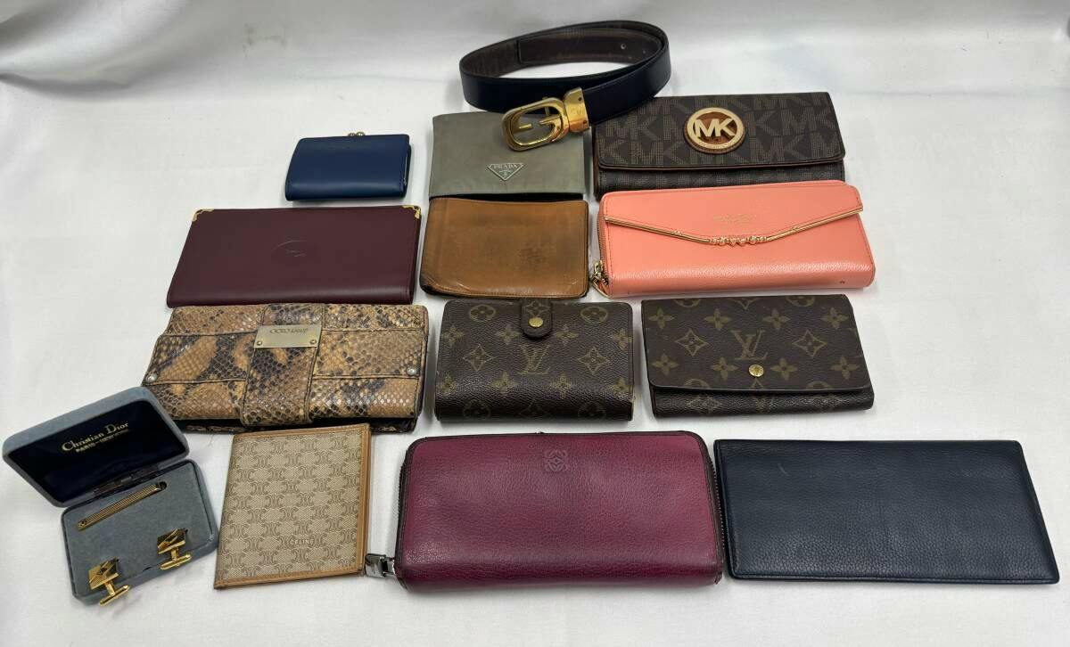 Laid-out collection of 14 wallets and small accessories, including Louis Vuitton monogram pieces and a belt, arranged on a white background.