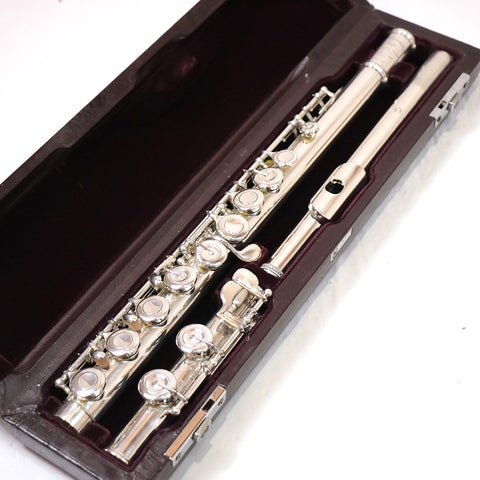 Silver Muramatsu flute disassembled into headjoint, body, and footjoint resting in a velvet-lined hard case.
