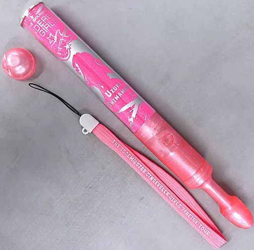 Pink Shimamura Uzuki concert pen light (Glowing Rock! ver.) with wrist strap and removable cap on a gray background.