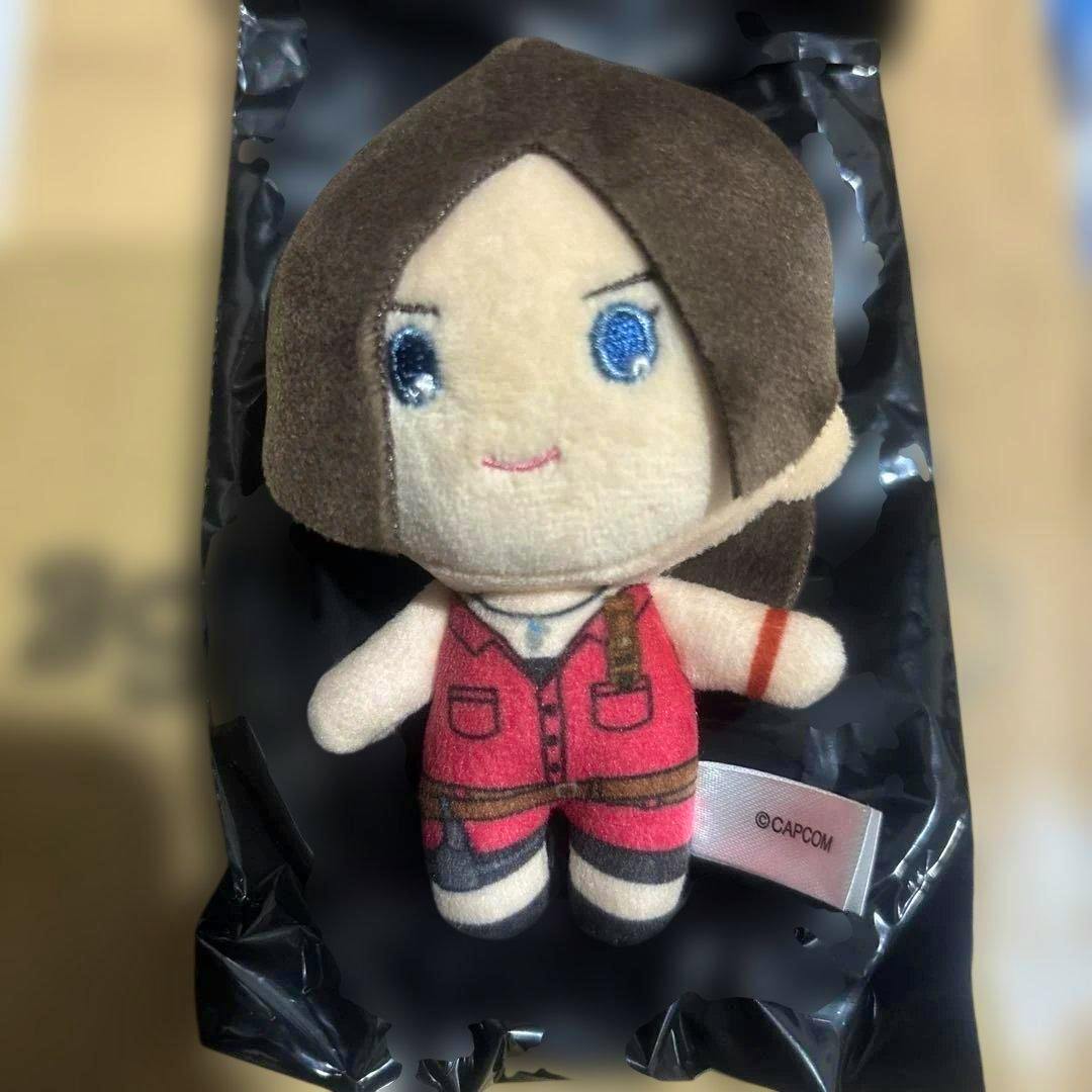 Front view of the plush collectible mascot Claire (Biohazard) wearing a red outfit, with embroidered facial features and a visible CAPCOM tag.