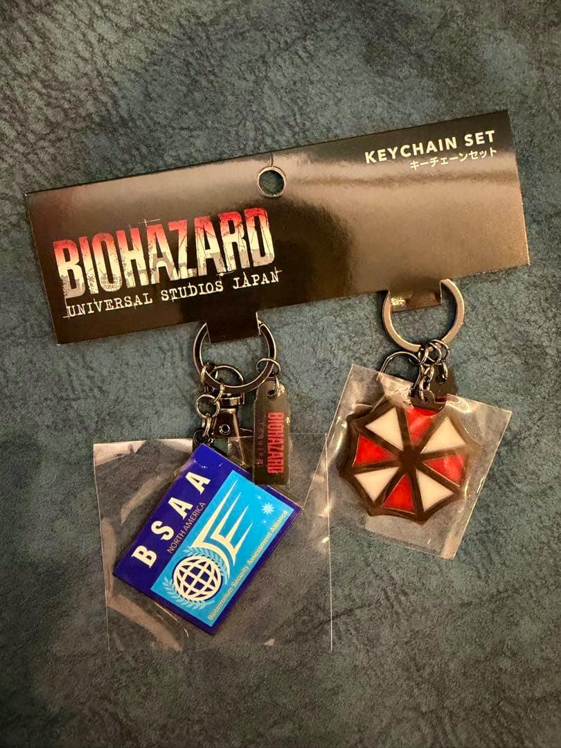 Photo of the USJ limited Biohazard keychain set showing two keychains attached to the branded backing card.