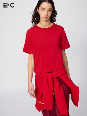 Model wearing a red relaxed-fit women's shirt with a tied garment at the waist.