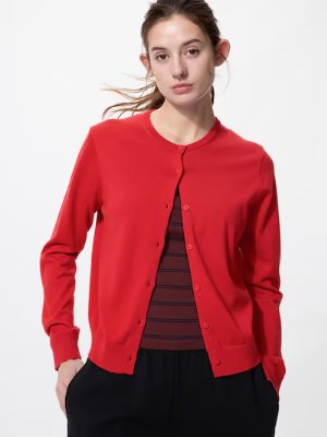 Model wearing a red crew-neck cardigan with buttons over a striped top against a white background.