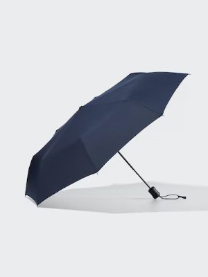A navy compact umbrella opened on a light background.