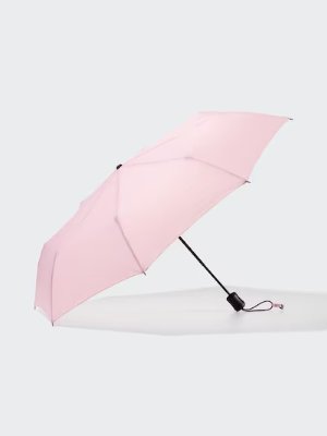 Open pink compact umbrella with a black shaft and wrist strap on a plain background.