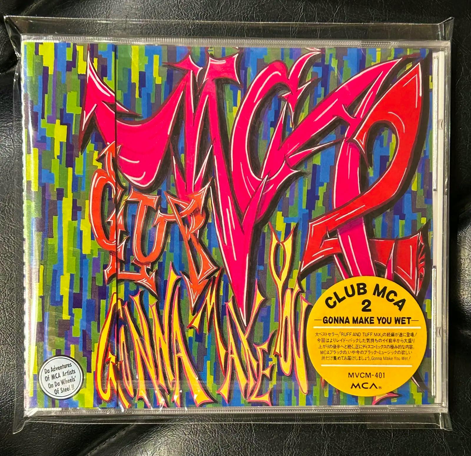 Sealed CD case front showing colorful graffiti-style cover art and a yellow "CLUB MCA 2 - GONNA MAKE YOU WET" sticker.