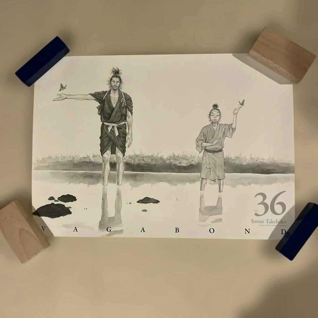 Poster for Vagabond volume 36 showing two standing characters reflected in water with the text “36” and “VAGABOND.”