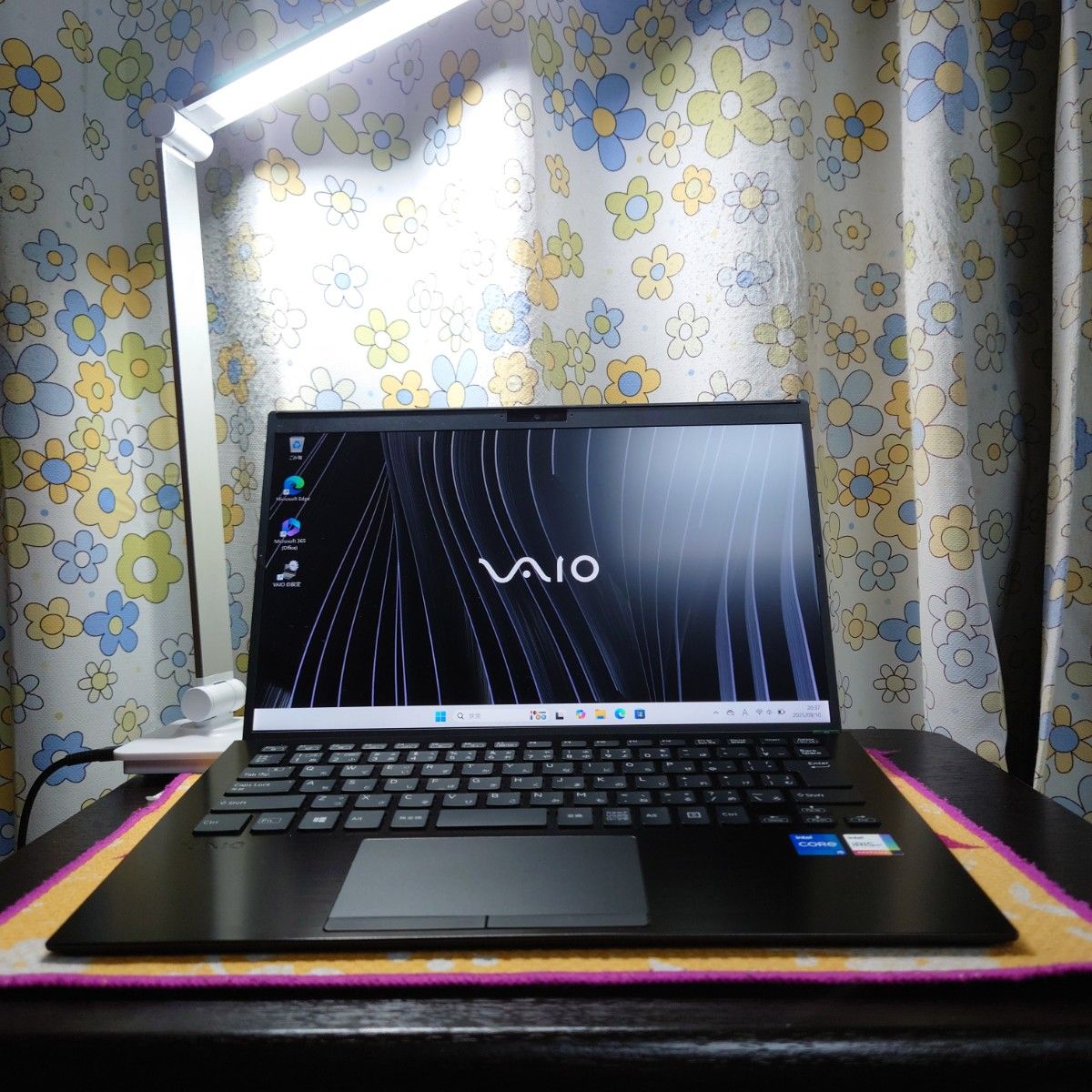 Open VAIO laptop on a table showing the screen with the VAIO logo and the keyboard.
