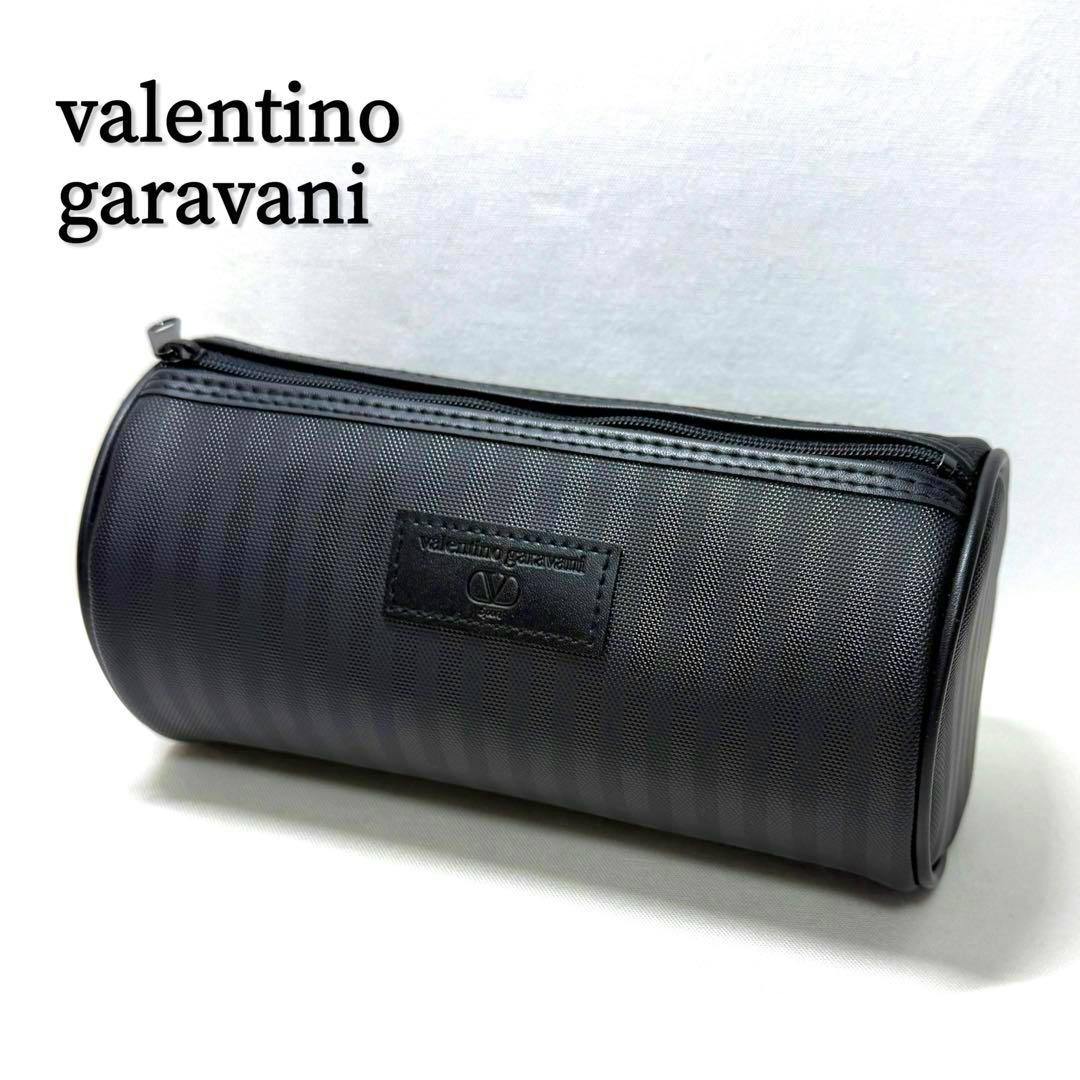 Black Valentino Garavani cylindrical canvas pouch with a top zipper and a front logo patch.