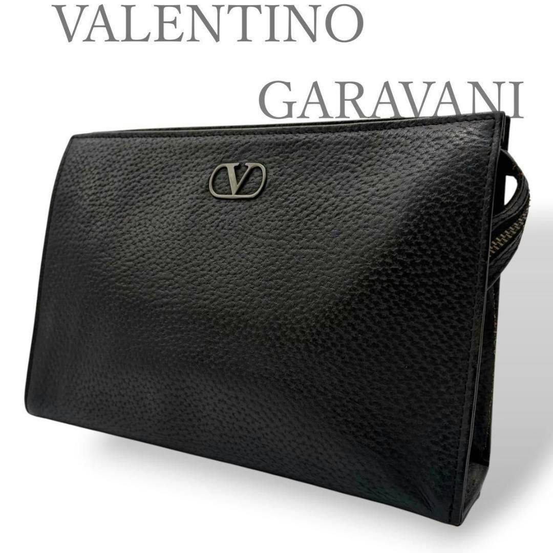Black Valentino Garavani leather clutch bag displayed at a three-quarter angle showing the metal V logo and side zipper.