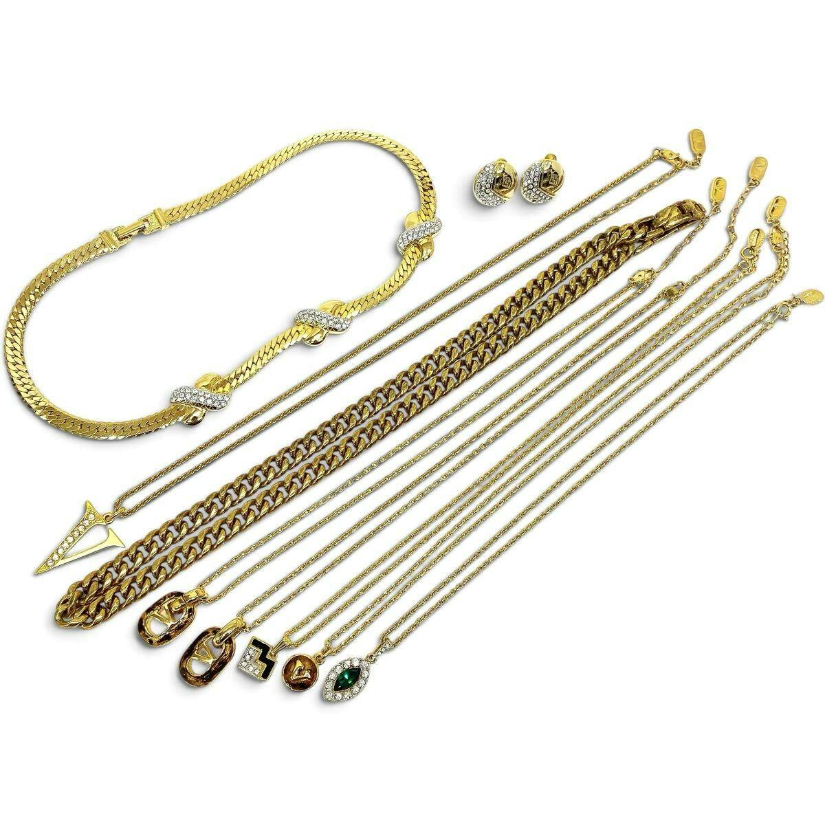Nine Valentino gold-color necklaces and earrings arranged flat on a white background.