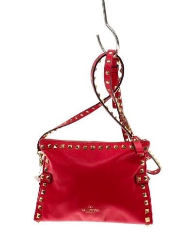 Front view of the VALENTINO canvas shoulder bag in pink with gold pyramid studs and an adjustable shoulder strap.
