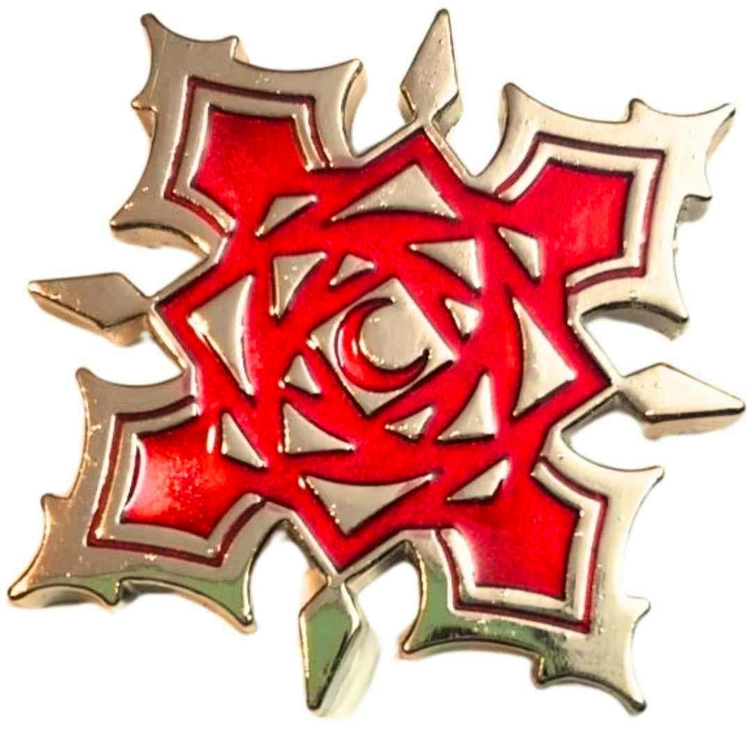 Close-up of a red and gold metal badge/pin with a stylized rose design, shown as the product.