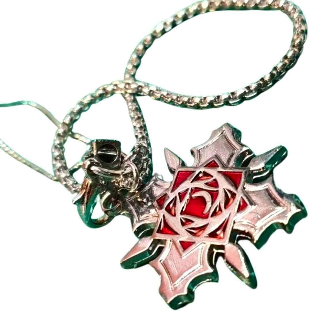 A zinc-alloy bag charm showing a silver, cross-shaped rose emblem with red enamel center and its attached chain and clasp on a white background.
