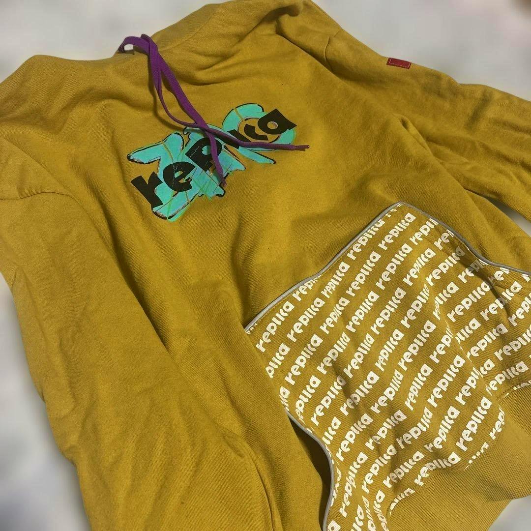 Mustard-yellow Vaundy replica hoodie laid flat showing the front graphic, purple drawstrings, and patterned kangaroo pocket.