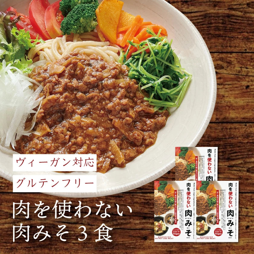 Bowl of noodles topped with vegan meat-style miso and vegetables with three packaged servings shown.