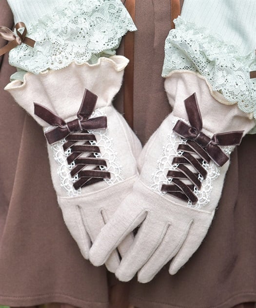 Close-up of hands wearing light beige velour ribbon lace-up gloves with decorative lace trim.
