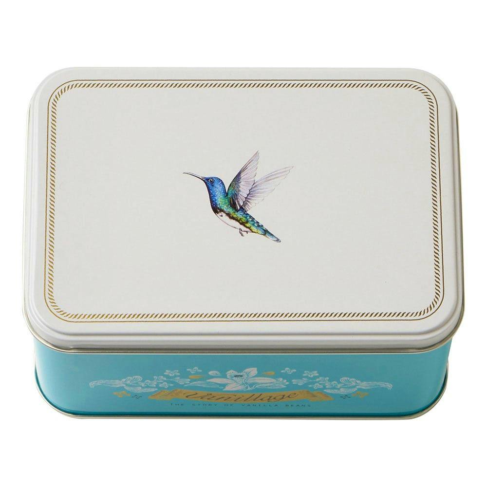 Rectangular turquoise and white tin of packaged cookies with a hummingbird illustration on the lid.