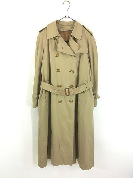 Beige double-breasted trench coat hanging on a hanger against a white background.