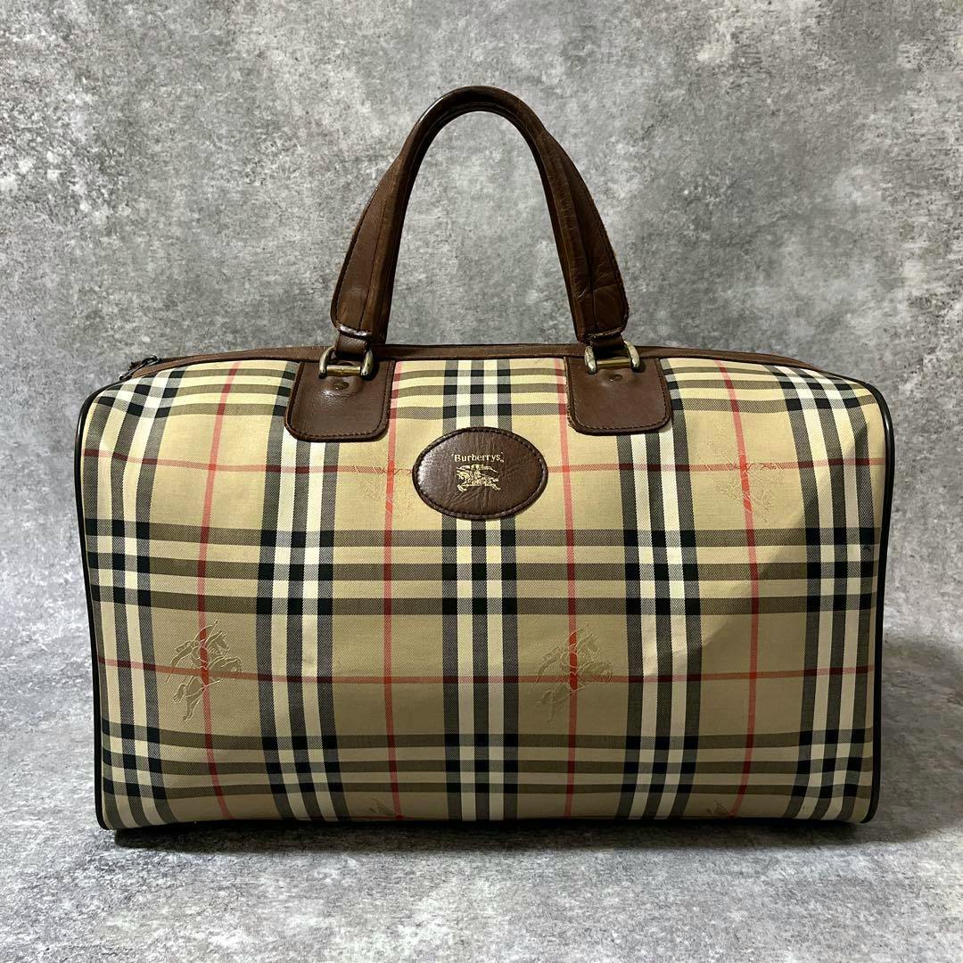 Front view of a vintage Burberrys Nova Check Boston travel bag with leather handles and an oval logo plaque.