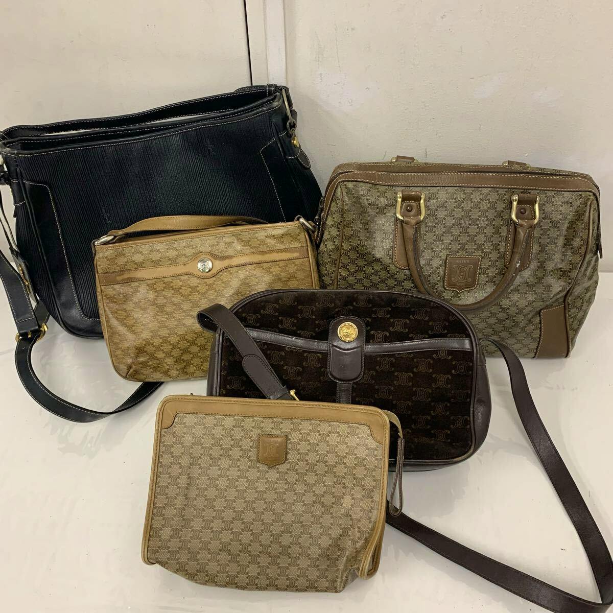 Multiple vintage branded bags (shoulder, handbag, and clutch styles) grouped on a white surface.