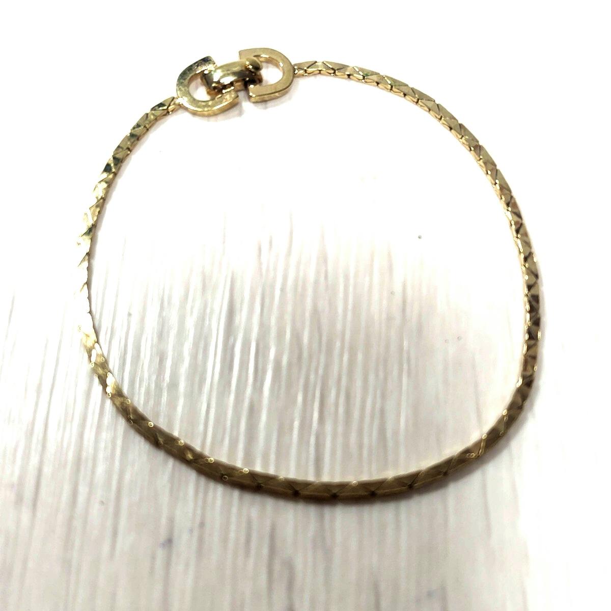 Gold-tone Christian Dior bracelet laid flat showing the textured chain and double-link clasp on a white surface.