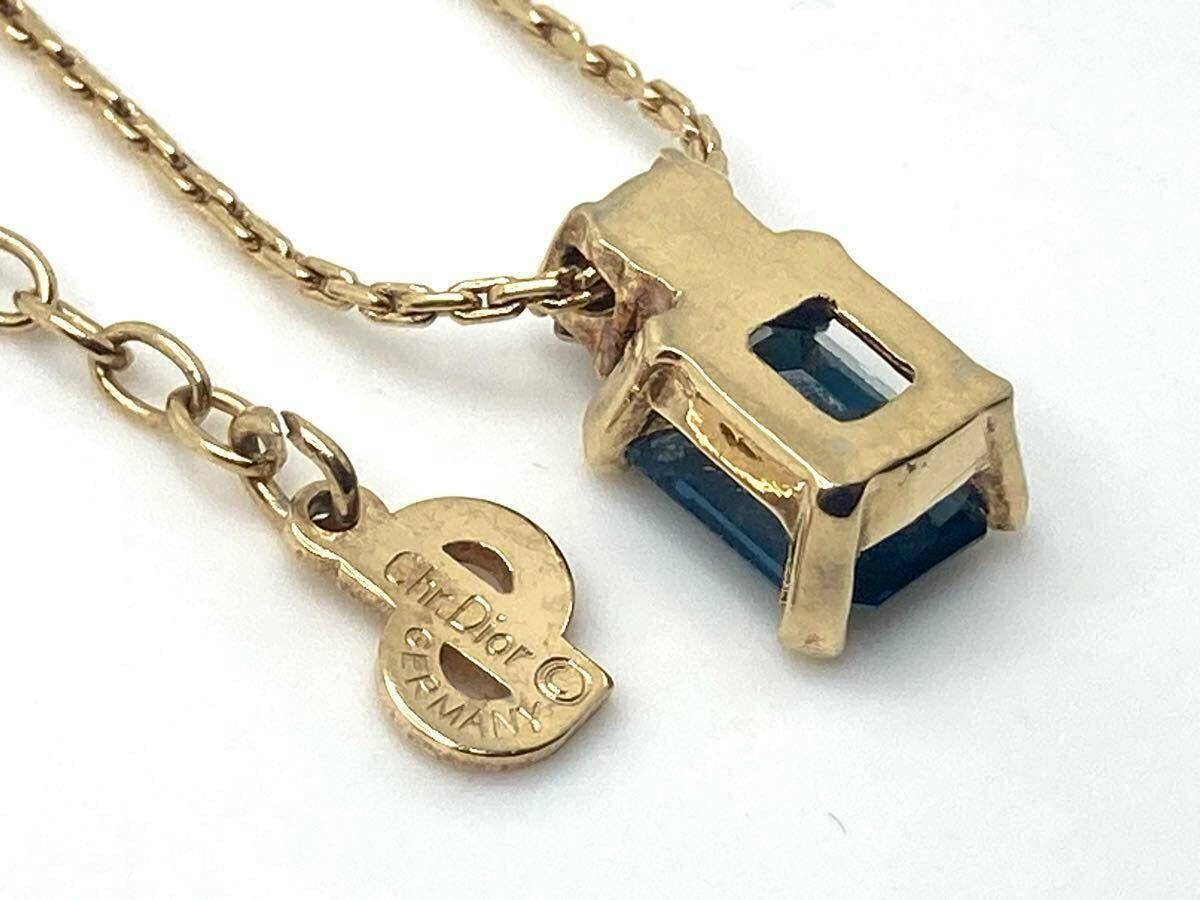 Close-up of the necklace pendant back and chain showing a blue square stone set in gold-color metal and a small round Christian Dior "Germany" tag.