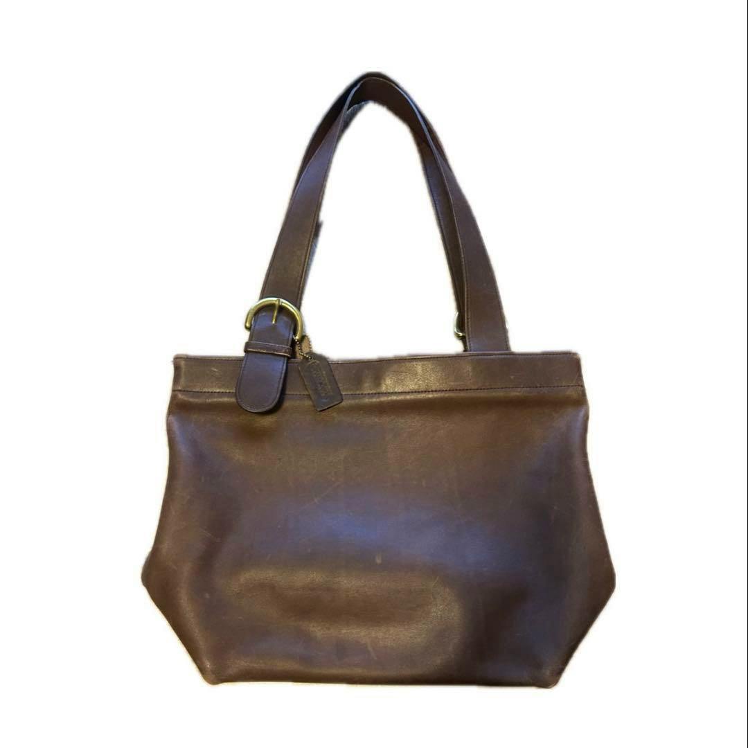 Brown leather handbag with two shoulder straps and a buckle detail photographed on a white background.